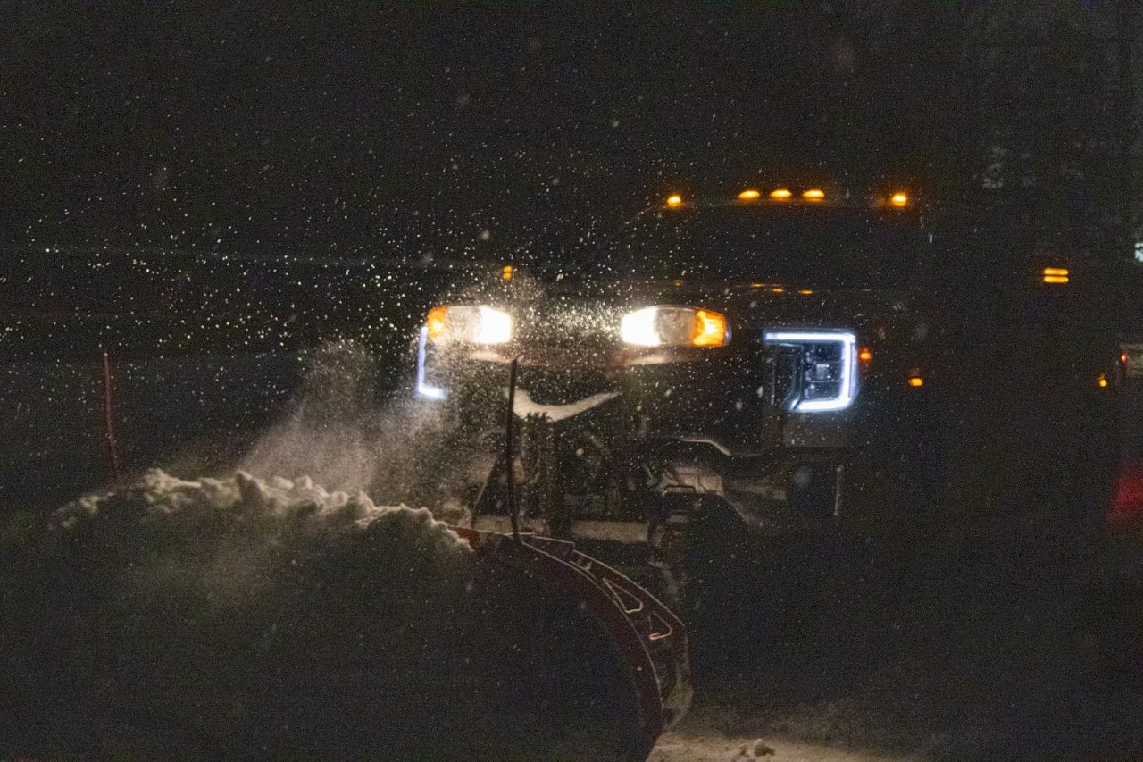 truck plowing snow at night in the winter.